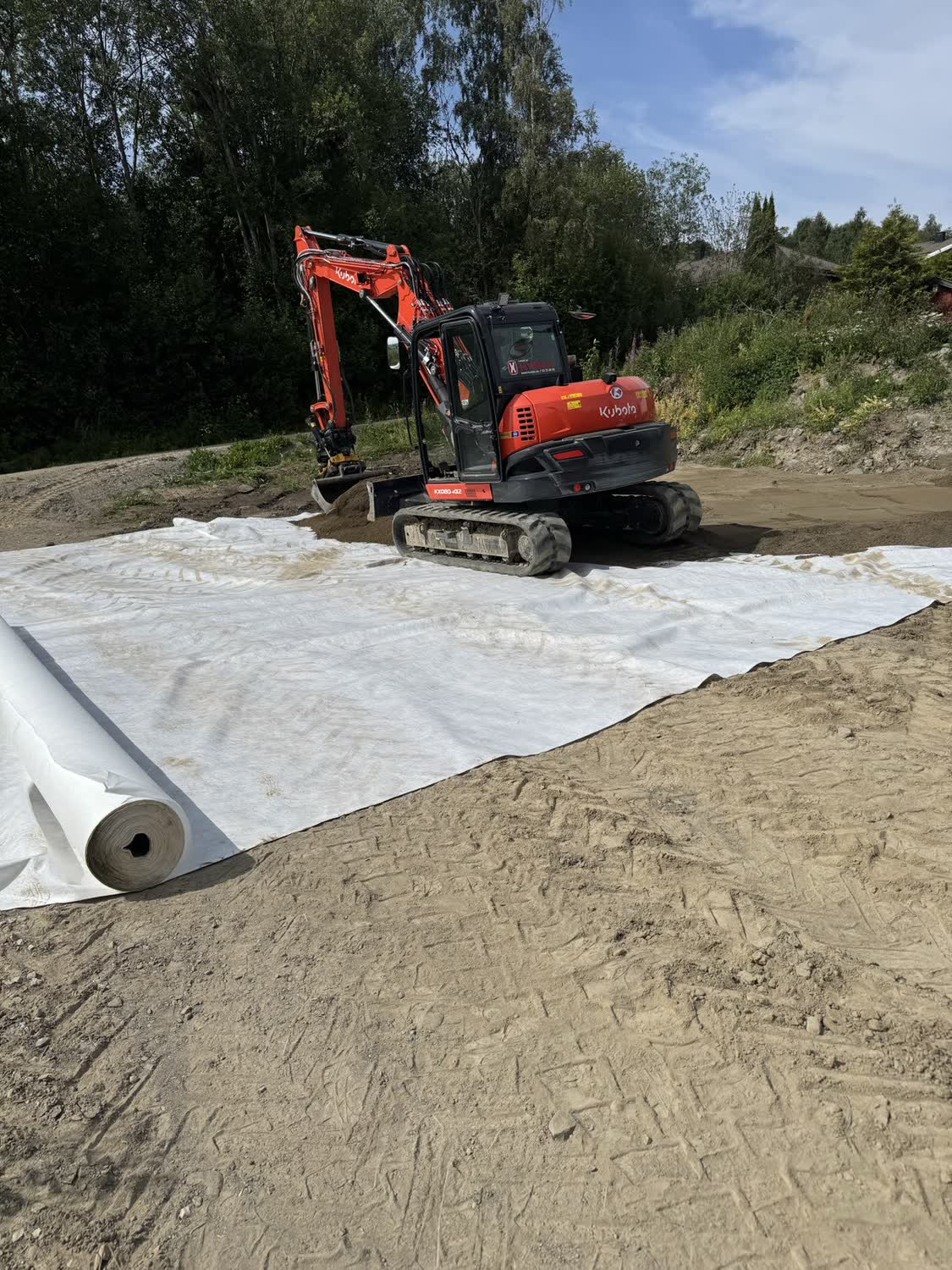 Fiberduk rullet ut på planert flate før bærelaget legges