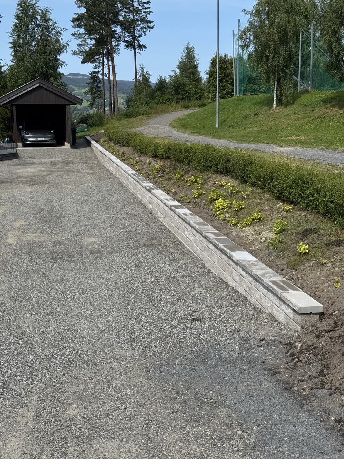 Ferdig kantstein i betong langs grusoppkjørsel