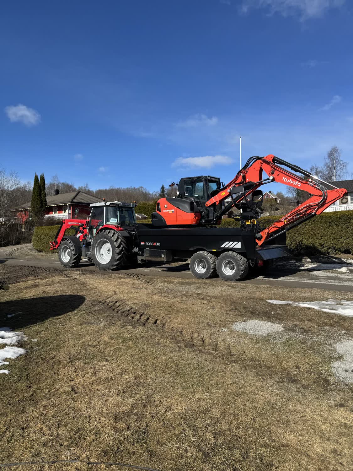 Gravemaskin lastet på boggihenger